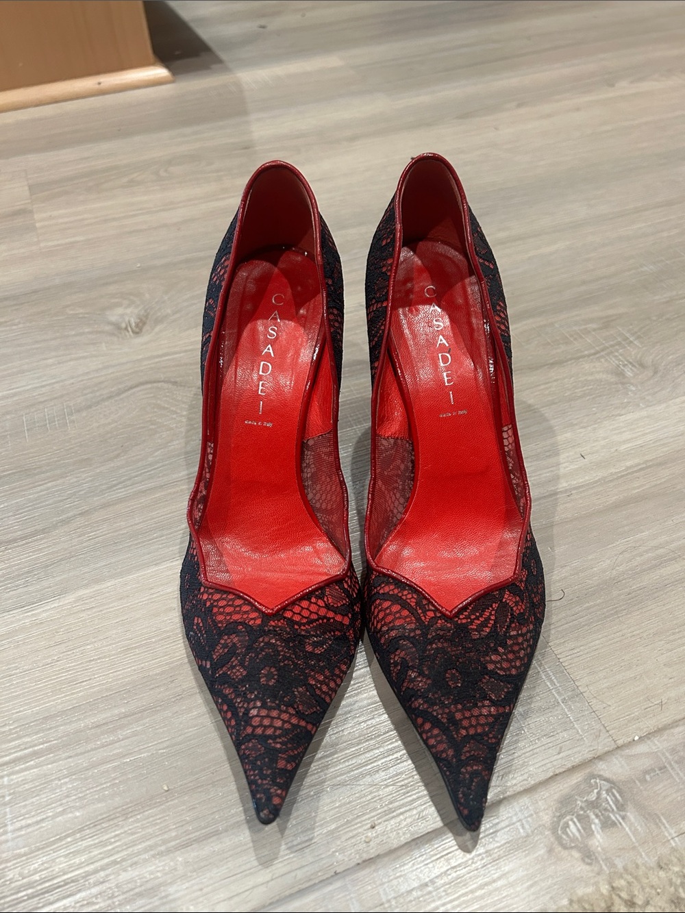 Casadei red leather pumps with a black Chantilly lace overlay.